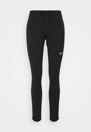 Zwarte sportlegging met een trekkoord in de taille, gemaakt van rekbare stof, met een klein wit Nike-logo op de linker bovenbeen.