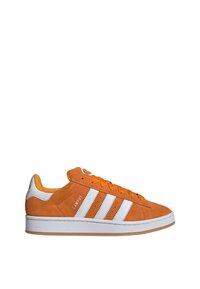 Narancssárga velúr sneaker fehér bőr csíkokkal, texturált felülettel és gumitalppal. Jellemzői a narancssárga fűzők és a párnázott bokarész.