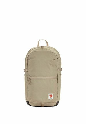 Zaino beige con tasca frontale con cerniera, cinturini laterali, manico superiore e piccolo logo della volpe rossa nell'angolo in basso a destra.