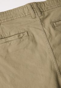 Beige cotton trousers with a smooth texture. Features a waistband, two back pockets, and visible stitching details.
