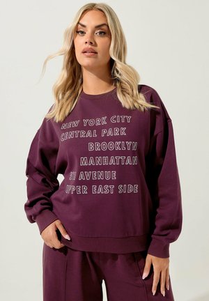 Lila Sweatshirt mit weißem Text "NEW YORK CITY", "CENTRAL PARK", "BROOKLYN" und mehr. Lässiger, lockerer Schnitt mit gerippten Bündchen.