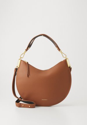 Brown leather handbag with a curved design, gold hardware accents, and a detachable shoulder strap. Features a textured surface and logo detail.