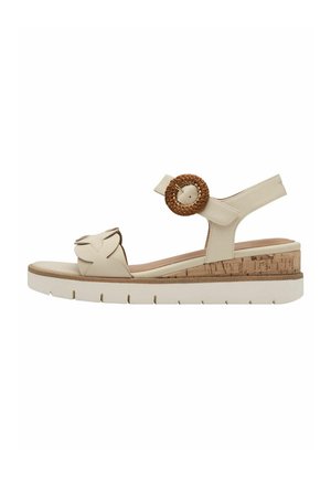 Il sandalo beige presenta una larga fascia con un design floreale, un accent in corda rotondo, un tacco in sughero e una suola bianca flessibile.