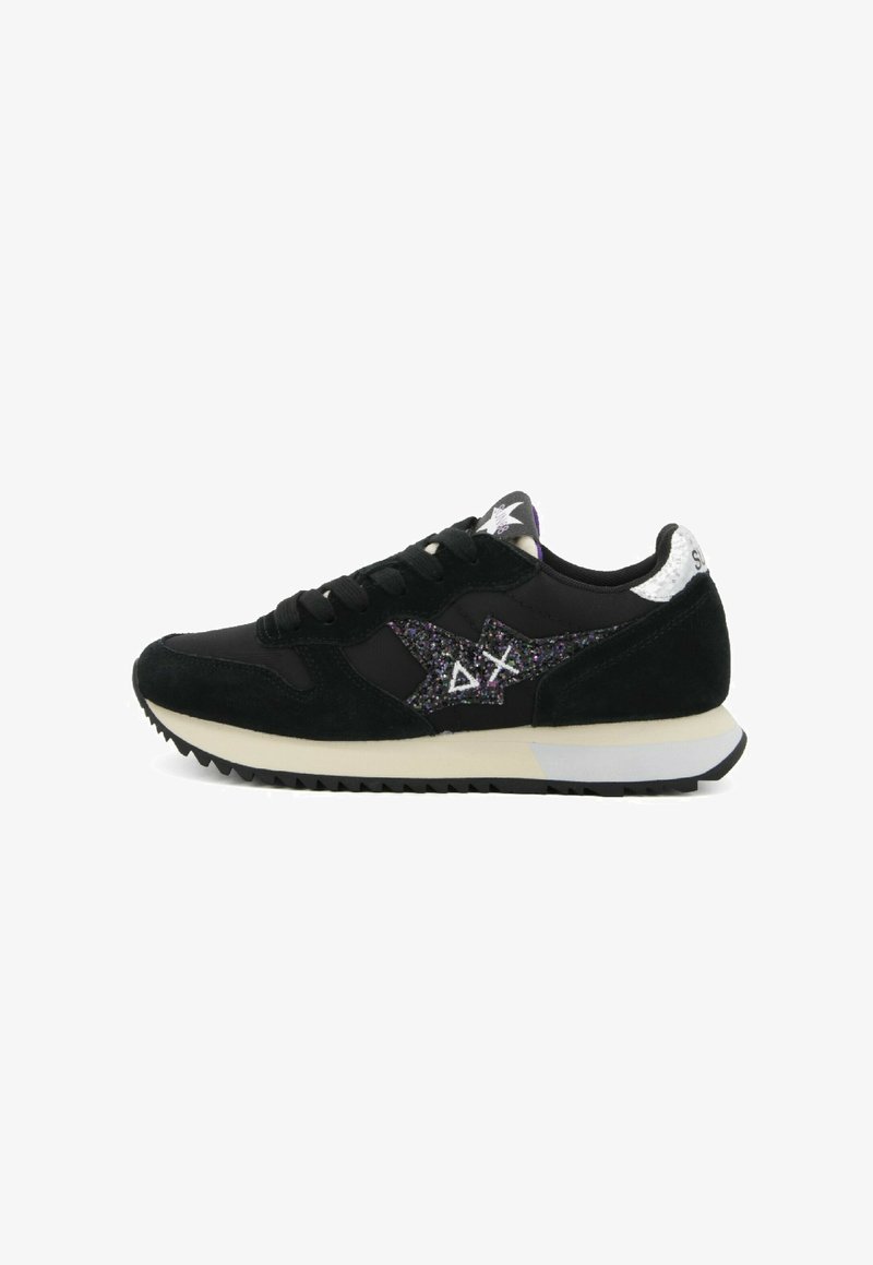 Sneaker nera con parte superiore in suede e tessuto, caratterizzata da un design con una stella luccicante, accenti bianchi e una suola in gomma testurizzata.