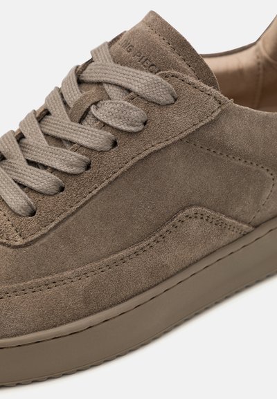 Baskets en daim marron avec un bout rond, dessus texturé et lacets plats. Elles présentent une semelle en caoutchouc à profil bas et des détails de couture subtils.