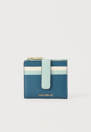 Kompaktowy skórzany portfel w kolorze niebieskim z jasnoniebieskimi i białymi poziomymi paskami, złotym zamkiem błyskawicznym i przednim paskiem z zatrzaskiem, markowy Coccinelle.