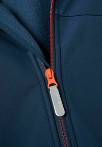 Chaqueta navy con tirador de cremallera naranja, que presenta un exterior suave y un forro interior texturizado y suave. La cremallera tiene un acabado metálico en plata.