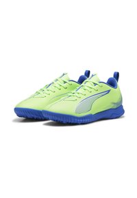 Zapatillas deportivas verdes lima con acentos azules, parte superior sintética texturizada, cierre de cordones y suela de goma con un patrón antideslizante.