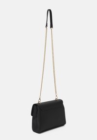 Bolso negro hecho de material texturizado, con una forma estructurada, cierre de solapa a presión y una correa de cadena dorada.