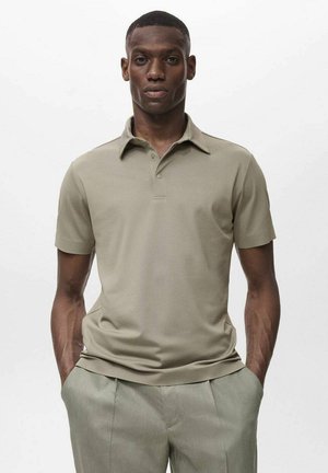 Khaki poloshirt met een kraag, korte mouwen en een subtiele textuur. Gemaakt met lichtgekleurde broeken voor een gecoördineerde uitstraling.