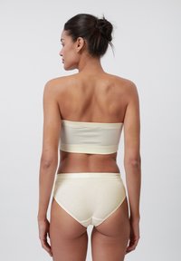 Vaaleankeltainen ribbikuvioinen bandeau-toppi ja korkeavyötäröiset alushousut, joissa on sileä pinta ja minimalistinen muotoilu.