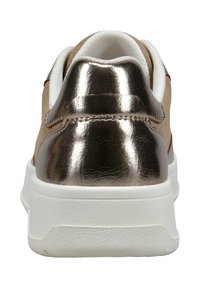 Beige Wildleder-Sportschuh mit einem metallisch bronzefarbenen Absatz, weißer Zwischensohle und strukturierten Gummisohle. Die Rückansicht hebt die Nahtdetails hervor.
