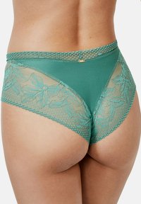 Teal kanten bikini ondergoed heeft accenten van een bloemenpatroon, een mesh overlay en een golvende tailleband met een klein gouden embleem detail.