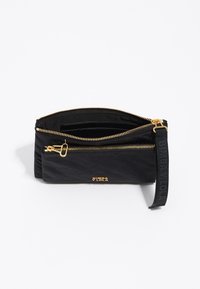 Bolsa con cremallera negra hecha de material texturizado, con herrajes dorados, dos compartimentos y una correa de tela con la marca.
