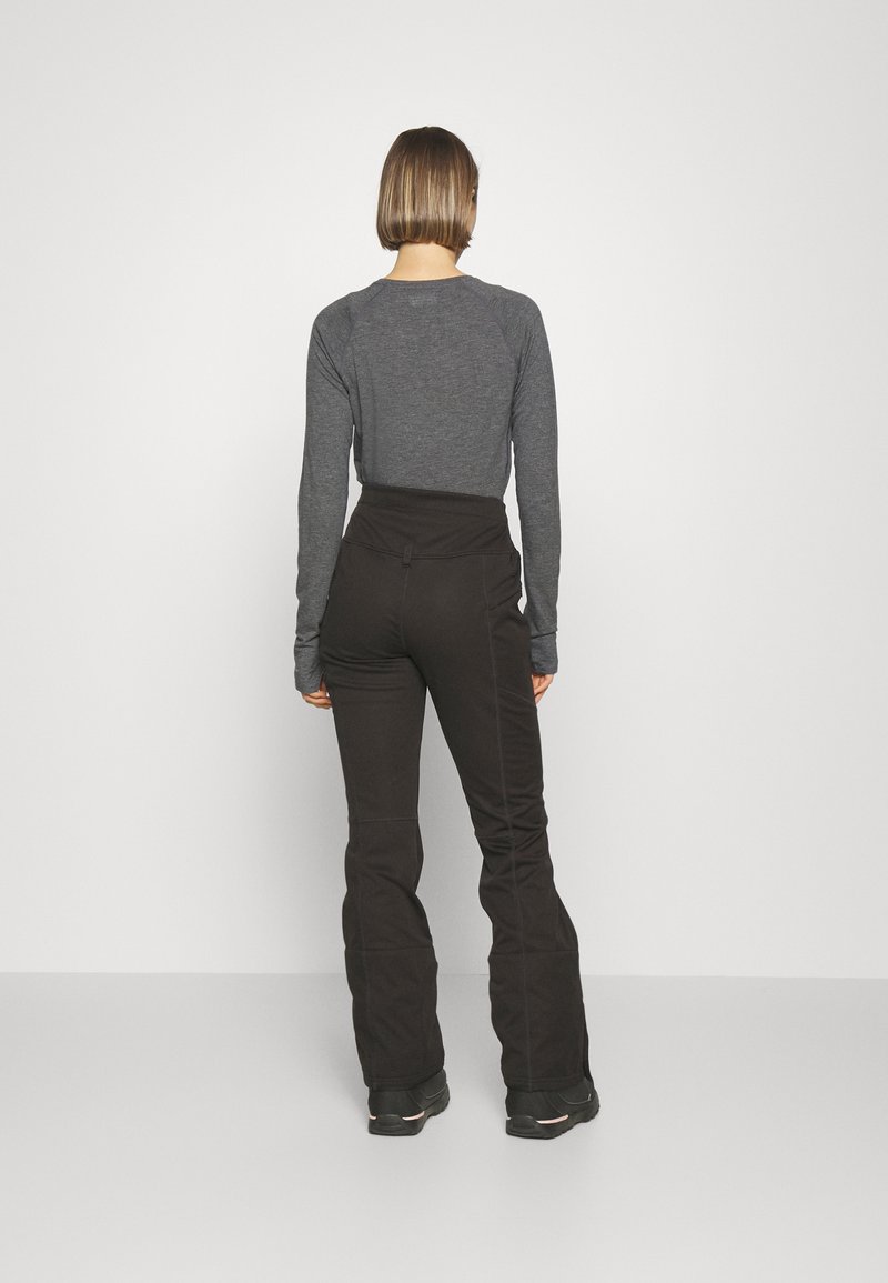 Szary długi rękaw z raglanowymi rękawami, zestawiony z czarnymi spodniami o wysokim stanie. Obie odzież cechuje gładka tekstura i dopasowany krój.