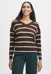Pull rayé marron et menthe avec un col en V, présentant des manches larges et un design court. Tissu doux avec une texture lisse.