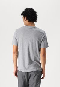 Grå bomulds T-shirt med korte ærmer, rund hals og en glat overflade. Ingen synlige mønstre eller detaljer set bagfra.
