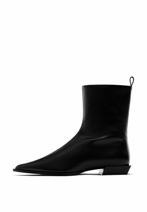 Sort læderstøvle til anklen med spids tå, lav vinklet blokhæl og trækfane bagpå.