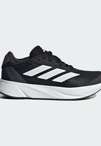 Le scarpe da allenamento nere presentano una tomaia in mesh testurizzato, strisce bianche a contrasto, un collare imbottito e una suola bianca leggera.