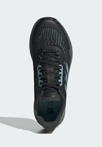 Scarpe sportive nere con parte superiore in rete e accenti blu. Presentano un design testurizzato, chiusura con lacci e suola in gomma per trazione.