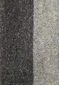 Tessuto di denim in bianco e nero che mostra una dettagliata trama diagonale e texture con un chiaro contrasto tra i due colori.