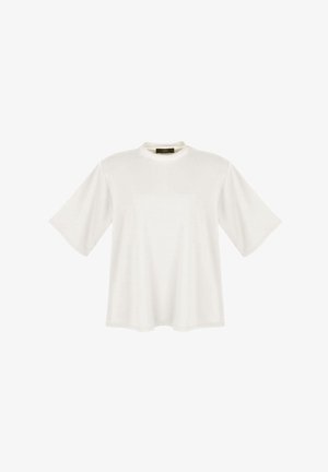 Biała, oversize'owa koszulka z krótkim rękawem i okrągłym dekoltem, z czarną metką na wewnętrznej stronie tylnego kołnierza.