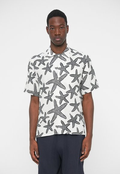 Chemise à manches courtes en tissu blanc avec un motif d'étoiles de mer noires, équipée d'un col boutonné et d'une poche sur le côté gauche.