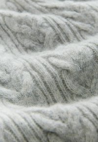 Helehall hallitus, pehmea tekstuuriga, millel on väljendunud nöörimuster ja veidi laiguline välimus.