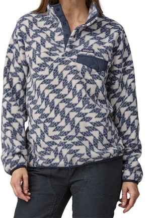 Fleece trui met lange mouwen met blauw-wit geometrisch patroon, borstzak met knopen en drukknoopsluiting aan de voorkant, gedragen door een persoon.