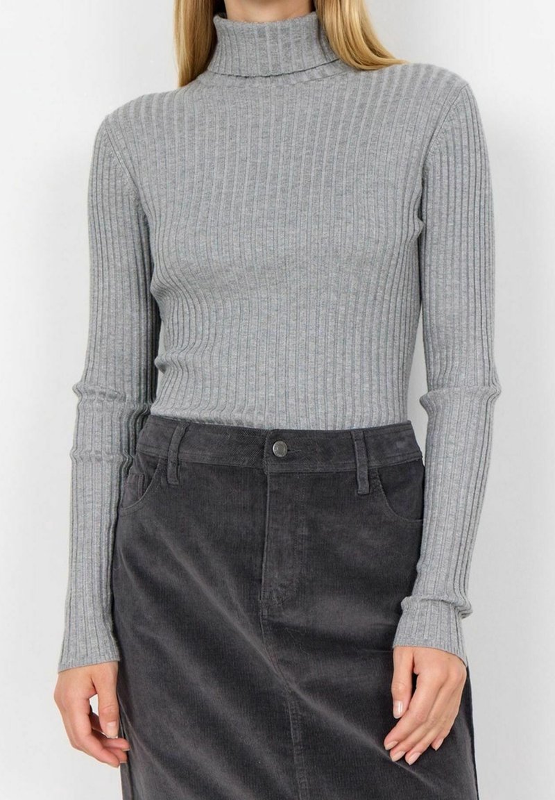 Pull à col roulé gris côtelé à manches longues, avec une coupe ajustée et un col montant, associé à une jupe en velours côtelé foncé.