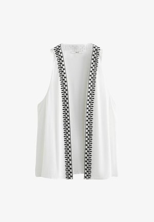 Valkoinen hihaton toppi, jossa on musta brodeerattu kukkakuosi avonaisilla etureunoilla; kevyt kangas, jossa on teksturoitu pinta.