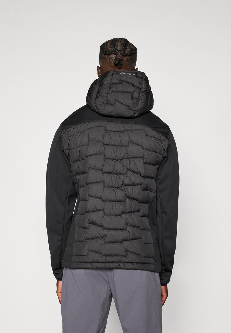 Czarna kurtka z puszystym, ocieplanym tyłem i gładkim przodem, z kapturem i ściągaczami przy mankietach. Projekt zawiera fakturowane szwy.