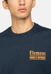 Navyblauwe katoenen T-shirt met een ronde hals en een oranje grafische opdruk met de tekst "Element DOING IT ANYWAYS" op de voorkant.
