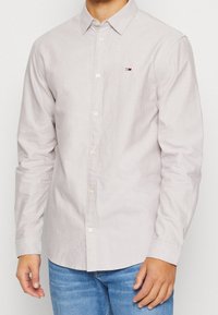 Lichtgrijs overhemd met lange mouwen en knopen, gemaakt van een katoenmengsel, voorzien van een klein logo op de borst en een klassieke kraag.