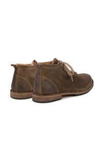 Brown leather ankle boots with rounded toe, lace-up front, and tan accents. Features a stitched sole and textured surface.