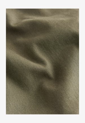 Tkanina w kolorze oliwkowym o gładkiej fakturze, z delikatnymi prążkami i fałdami, odbijająca światło w różnych odcieniach na powierzchni.