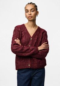 Vinröd stickad kofta med kabelmönster, v-ringad hals och tvåknappsstängning; textilier med struktur och ribbade muddar och nederkant.