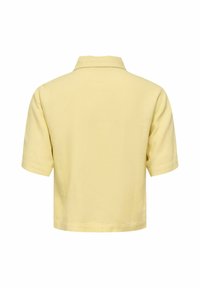 Polo manches courtes jaune pâle vu de dos avec col plié et design simple, sans coutures.