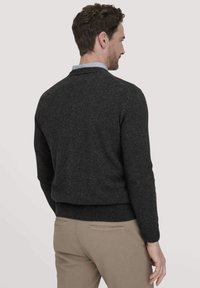 Dunkelgraue gestrickte Strickjacke mit taillierter Taille und gerippten Bündchen. Hat ein einfaches, klares Design mit einem klassischen Kragen und weicher Textur.