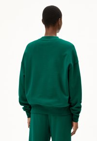 Grüne Sweatshirt mit leichtem Schnitt, Rundhalsausschnitt und ribbelten Bündchen. Aus weichem Material, das eine glatte Textur und ein minimales Design aufweist.