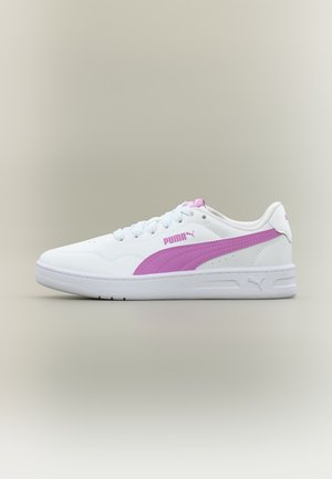 Λευκό παπούτσι Puma με ροζ λωρίδα λογότυπου, λευκά κορδόνια και επίπεδη σόλα σε ουδέτερο φόντο.