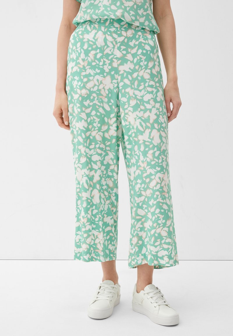 Mintgroene broek met bloemenprint, losvallend en cropped. Gemaakt van een lichtgewicht stof, met witte bloemenpatronen.