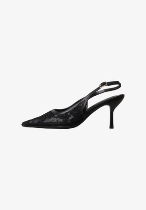 Zapato de tacón alto slingback negro con punta puntiaguda, superposición de encaje y una correa delgada con hebilla sobre fondo blanco.