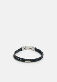 Vlechtleren armband in het zwart met een zilverkleurige sluiting en een gouden accent. Heeft een gladde textuur en een slanke, gebogen vorm.