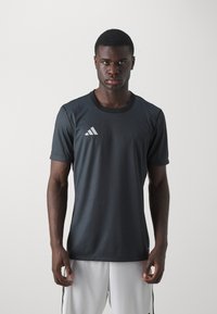 Sort atletisk t-shirt med korte ærmer, rund hals og et hvidt Adidas-logo på øverste venstre side; glat, åndbart stof.