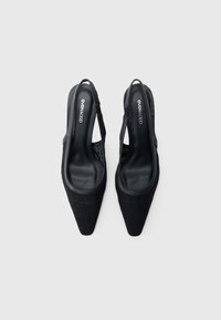 Μαύρα γόβες με λουράκι πίσω, μυτερά δάχτυλα, υφή στην επάνω επιφάνεια και γυαλιστερή μαύρη εσωτερική σόλα. Διαθέτουν λουράκι γύρω από τη φτέρνα για ασφαλή εφαρμογή.