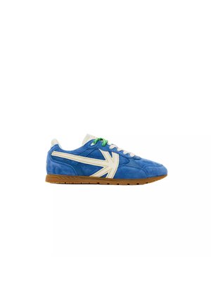 Blauwe suède sneaker met witte accenten, groene en witte veters en een gum rubberen zool, zijaanzicht op een witte achtergrond.