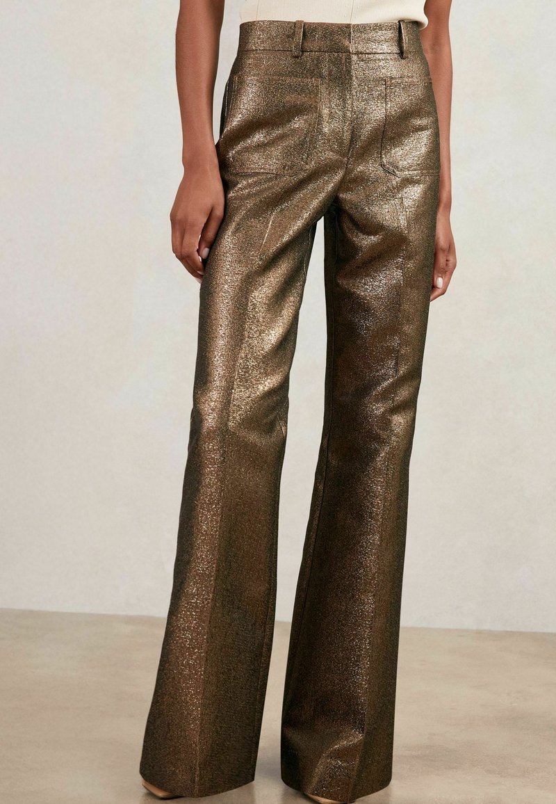 Glanzende, bronzen uitlopende broek met een textuurafwerking, voorzien van een hoge taille, zijzakken en een gladde stof die het licht weerkaatst.