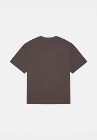 Brązowa koszulka z krótkim rękawem wykonana z bawełny. Posiada okrągły dekolt i luźny krój. Gładki design bez widocznych logo lub wzorów.