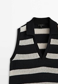 Gilet sans manches en maille rayée noir et blanc avec col côtelé et encolure en V.